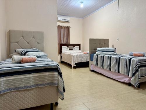 a bedroom with two beds and a table at Hotel Consalter in Rodeio Bonito