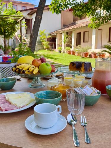ein Tisch mit Tellern voller Speisen und Getränken in der Unterkunft Antolina Hotel in Goiás
