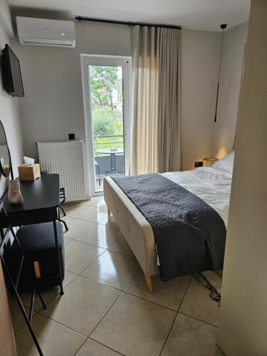 a bedroom with a bed and a desk and a window at addview 2 in Nafplio