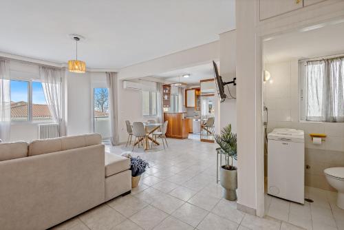 a living room with a couch and a kitchen at Fabulous central apartment close to the sea! in Chalkida