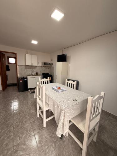 a white table and chairs in a room with a kitchen at frente del mirador in Tres Lagos