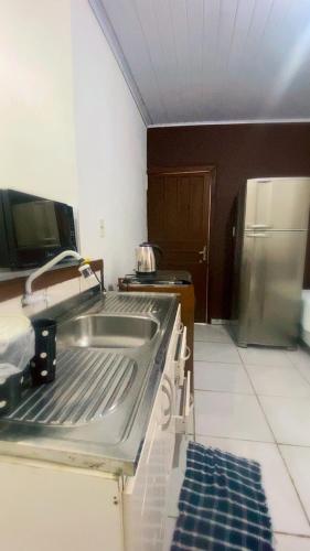 a kitchen with a sink and a refrigerator at Pousada da Heloisa in Imbituba