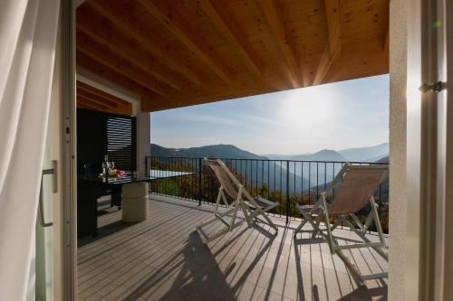 a balcony with two chairs and a table with a view at Il Bagnolo Eco Lodge in Salò