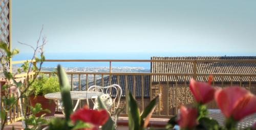 a balcony with a table and chairs and flowers at PortAtenea - Atenea Collection in Agrigento
