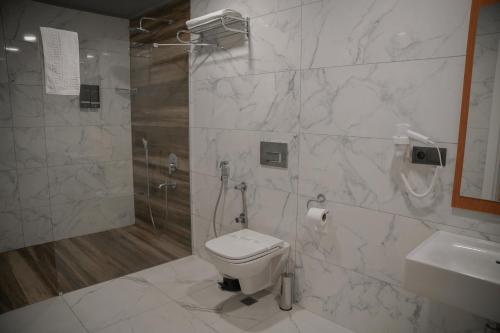 a bathroom with a shower and a toilet and a sink at The MU City Hotel Trabzon in Trabzon