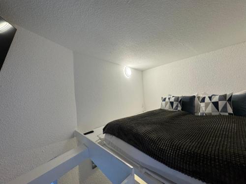 a small bedroom with a bed in a white room at Tiny Ferienhaus Rathenaustrasse in Reichenbach im Vogtland