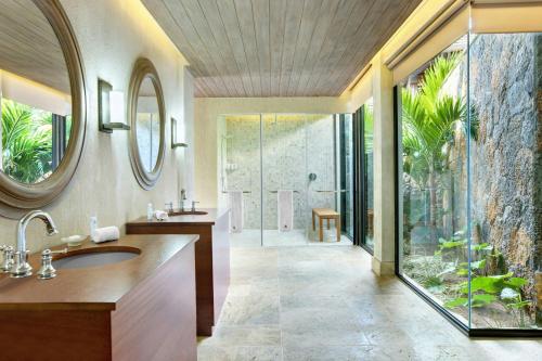 a bathroom with a sink and a glass shower at The St. Regis Le Morne Resort, Mauritius in Le Morne
