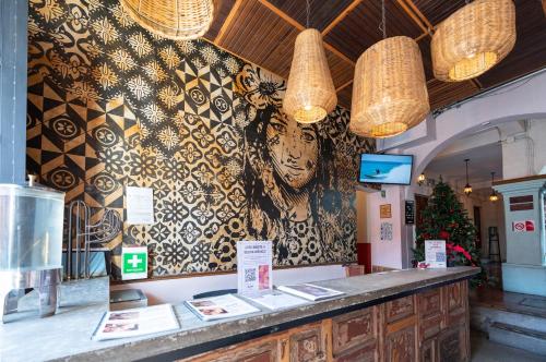 a restaurant with a wall with a mural of a face at Selina Oaxaca in Oaxaca City
