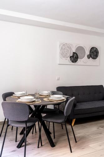 a dining room with a table and chairs and a couch at Apartamento Ponent Stays in Almacellas