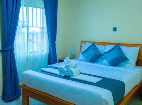 a bedroom with a bed with blue pillows at Fort Arch Eco-Lodges in Fort Portal