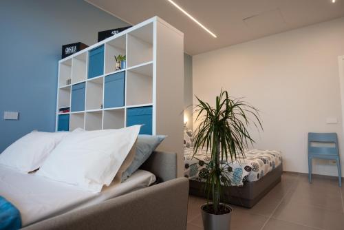 a bedroom with a couch and a bed in it at Al Ventisei - Azzurro in Treiso