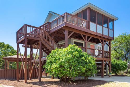 a large wooden house with a tree at 2058 - Blessed by the Sea Duck in Duck