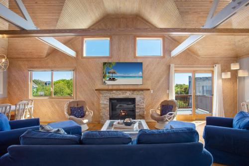 a living room with blue couches and a fireplace at 2058 - Blessed by the Sea Duck in Duck