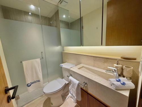 a bathroom with a toilet and a sink with a mirror at Zantamar 105B, a pie de playa in Cruz de Huanacaxtle