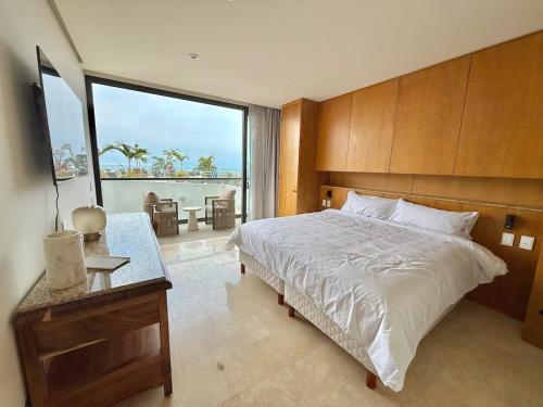 a bedroom with a bed and a view of the ocean at Zantamar 105B, a pie de playa in Cruz de Huanacaxtle