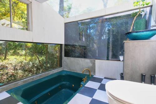 a bathroom with a tub and a toilet and a window at Vintage Lovers` Cabin with Jacuzzi & Lake Access in Linden
