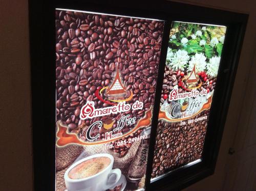 a sign for a coffee shop with a cup of coffee at Amaretto Hostel in Surat Thani