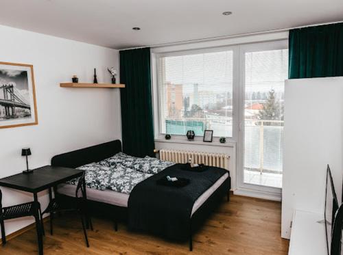 a bedroom with a bed and a table and a window at Apartmán Mlynská in Vranov nad Topľou