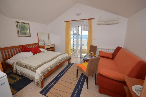 sypialnia z łóżkiem i kanapą w obiekcie Hotel Vila Margot w mieście Herceg Novi