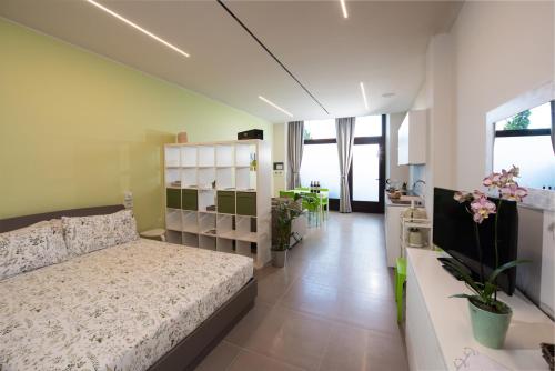 a bedroom with a bed and a room with plants at Al Ventisei - Verde in Treiso