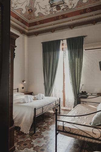 a bedroom with two beds and a ceiling at Golden house in Cefalù