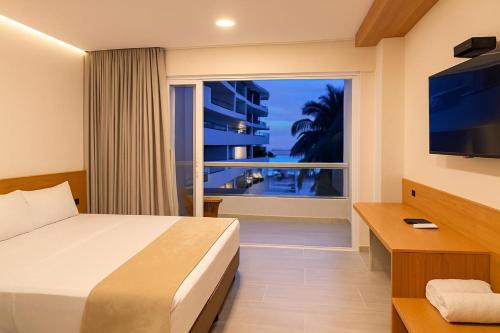 a hotel room with a bed and a large window at Stanza Del Mar in Coveñas