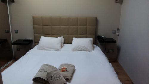 a bedroom with a white bed with towels on it at L'Arche de Porquerolles in Porquerolles