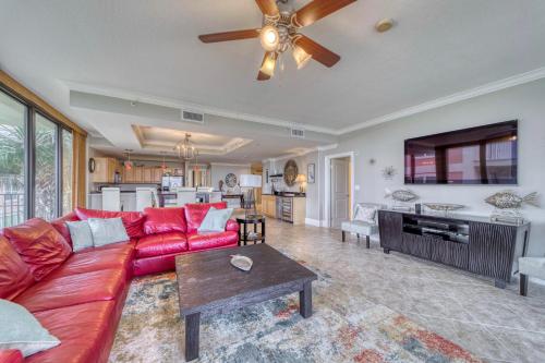 a living room with a red couch and a ceiling fan at Holiday Isle 122 in Dauphin Island