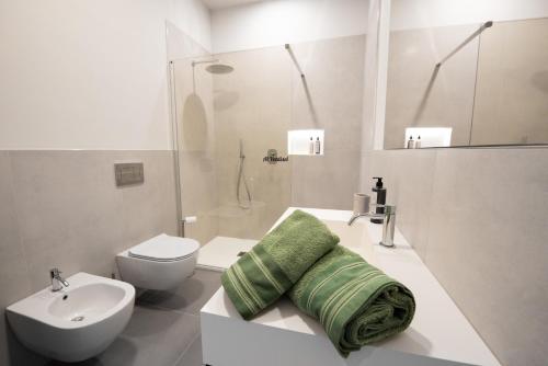 a white bathroom with a sink and a toilet at Al Ventisei - Verde in Treiso