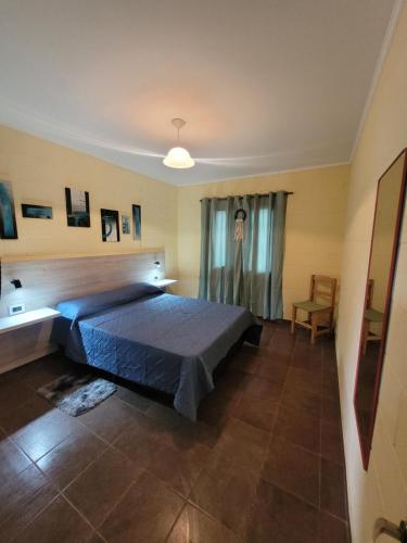 a bedroom with a blue bed and a chair at Balcones de Bialet in Bialet Massé