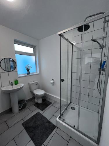 a bathroom with a glass shower and a toilet at Homely Whittier Terrace 3 Bedroom House in Nottingham