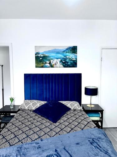 a bed with a blue headboard in a bedroom at Homely Whittier Terrace 3 Bedroom House in Nottingham
