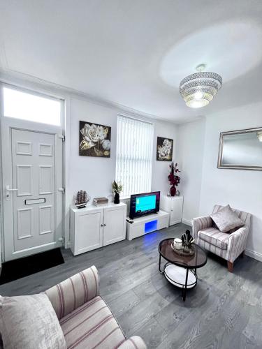 a living room with a couch and a tv at Homely Whittier Terrace 3 Bedroom House in Nottingham