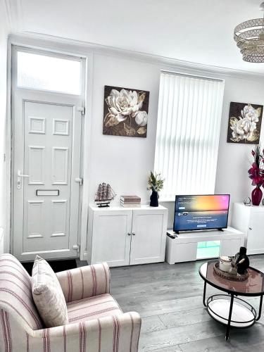 a living room with a couch and a tv at Homely Whittier Terrace 3 Bedroom House in Nottingham