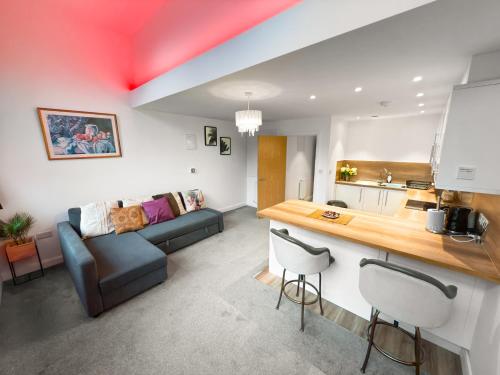 a living room with a couch and a kitchen at Flat 1 - Luxury Bolton City Centre Apartments in Bolton