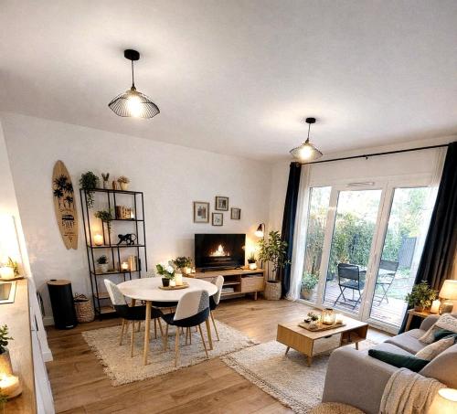 a living room with a table and a couch at Le Cottage Jardin élégant & cosy, plage pour 6 personnes, animaux admis Biscarrosse in Biscarrosse