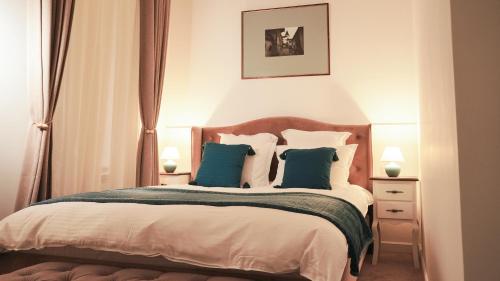 a bedroom with a large bed with blue pillows at Weiss Central Boutique in Braşov