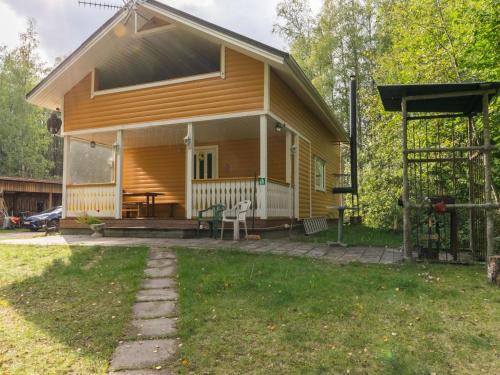 a small yellow house with a patio and a table at Holiday Home Pöllö by Interhome in Verla