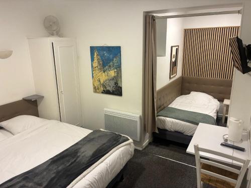 a hotel room with two beds and a mirror at Villa Hotel in Troyes