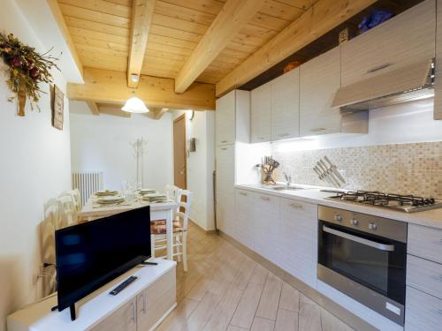 a kitchen with a television and a kitchen with a table at Apartment Casa del Bitto by Interhome in Pedesina