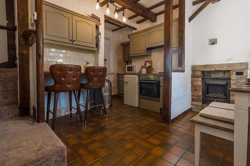 a kitchen with two bar stools and a stove at Hoot Cottage in Oakworth