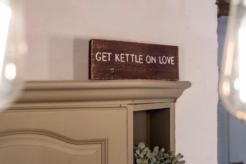 a sign sitting on top of a fireplace at Hoot Cottage in Oakworth