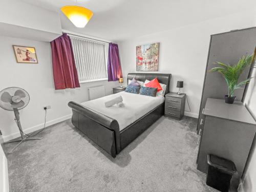 a bedroom with a bed and a desk with a fan at Flat 1 - Luxury Bolton City Centre Apartments in Bolton