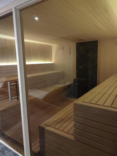 a sauna with wooden floors and a large glass window at Yellow Hill Apartment in Cajetina