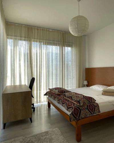 a bedroom with a bed and a desk and windows at RIX Apartments in Kyrenia