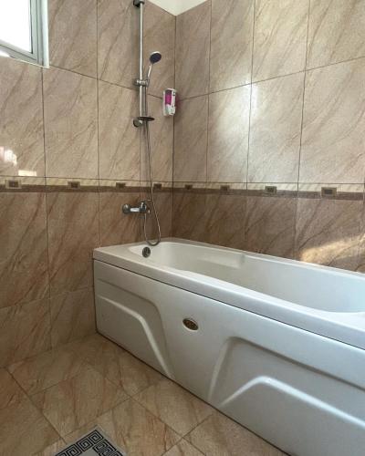 a bath tub in a bathroom with a shower at RIX Apartments in Kyrenia