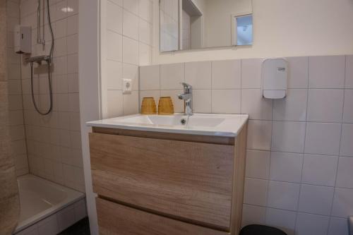 a bathroom with a sink and a bath tub at The Guesthouse in Gouda