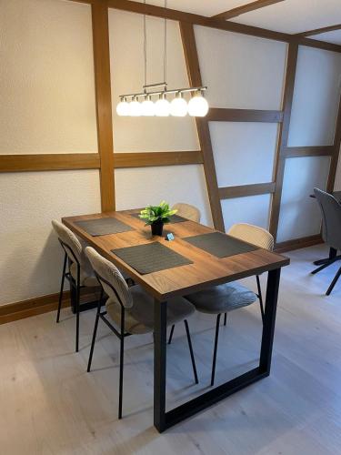 a wooden table with chairs and a potted plant on it at Studio with Kitchen & Parking near Thun and Bern in Herbligen 