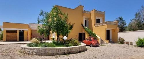 a small red car parked in front of a house at Villa PARADISO - Tra Ulivi e Tramonti da Cartolina in Muro Leccese