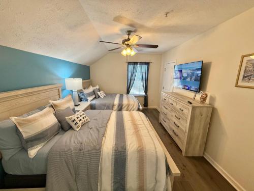 a bedroom with two beds and a flat screen tv at Contemporary 2-BR cottage, 2 Blocks to Beach in Myrtle Beach